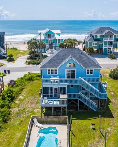Aerial view of colorful beachfront vacation homes with ocean and sandy beach in background